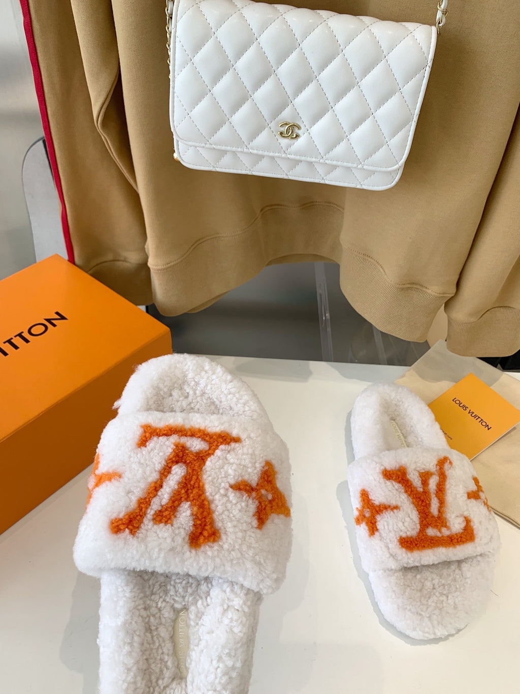 LV WOMEN'S PASEO FLAT SLIPPER IN WHITE FLEECE WITH ORANGE LOGO