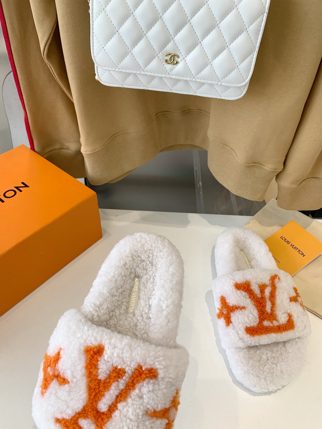 LV WOMEN'S PASEO FLAT SLIPPER IN WHITE FLEECE WITH ORANGE LOGO