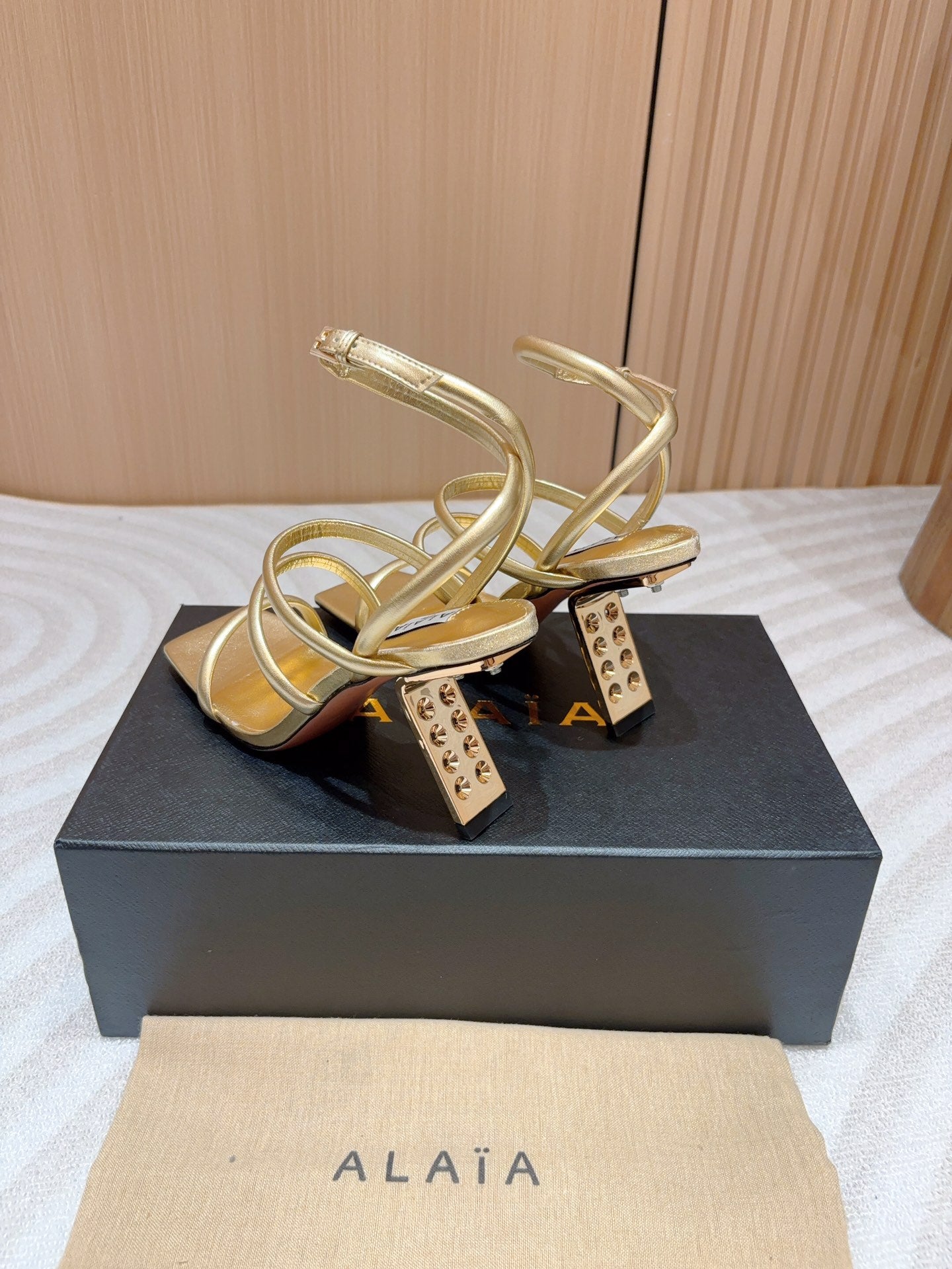 ALAIA THREE-STRAPS HIGH HEEL SANDALS IN GOLDEN PATENT LAMBSKIN