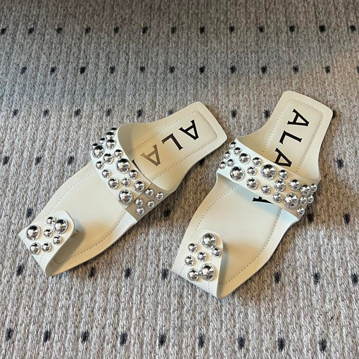 ALAIA FOLDED FLAT MULES WITH SPHERES ON WHITE CALFSKIN