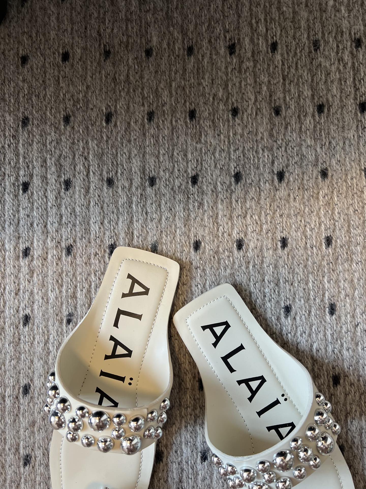 ALAIA FOLDED FLAT MULES WITH SPHERES ON WHITE CALFSKIN