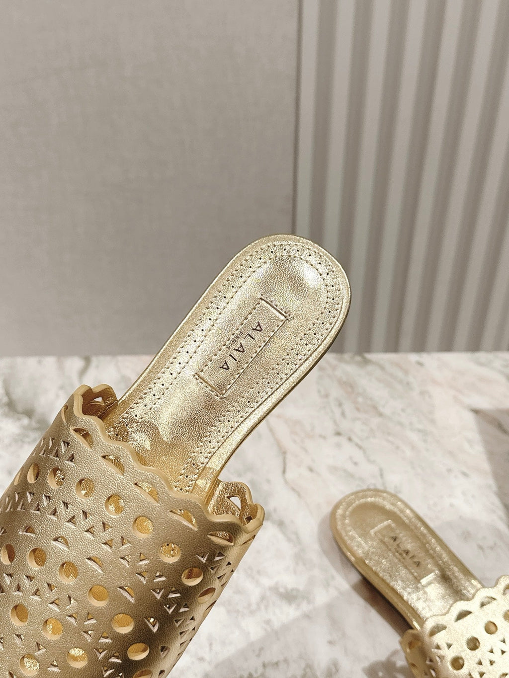 ALAIA PERFORATED SLIDE SANDALS 25S IN LIGHT GOLD LAMBSKIN