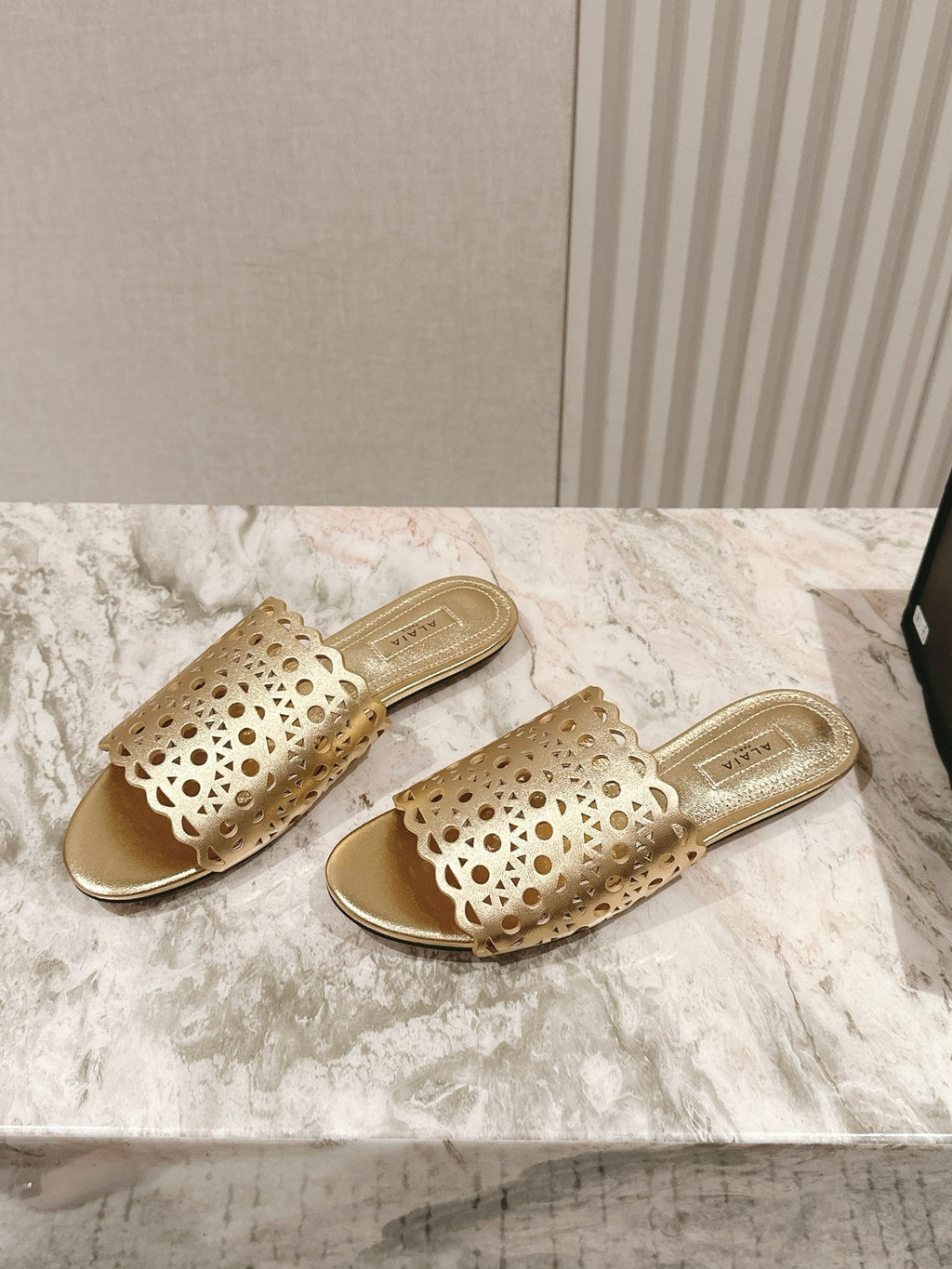 ALAIA PERFORATED SLIDE SANDALS 25S IN LIGHT GOLD LAMBSKIN