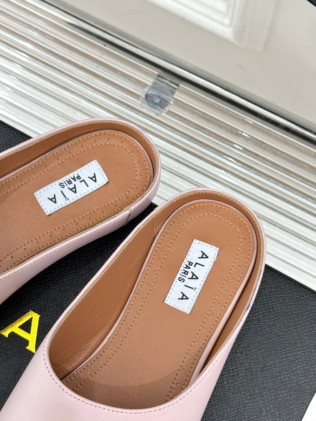 ALAIA FLAT MULE IN LIGHT PINK LAMBSKIN
