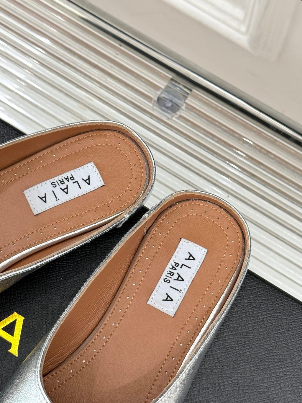 ALAIA FLAT MULE IN SILVER LAMBSKIN