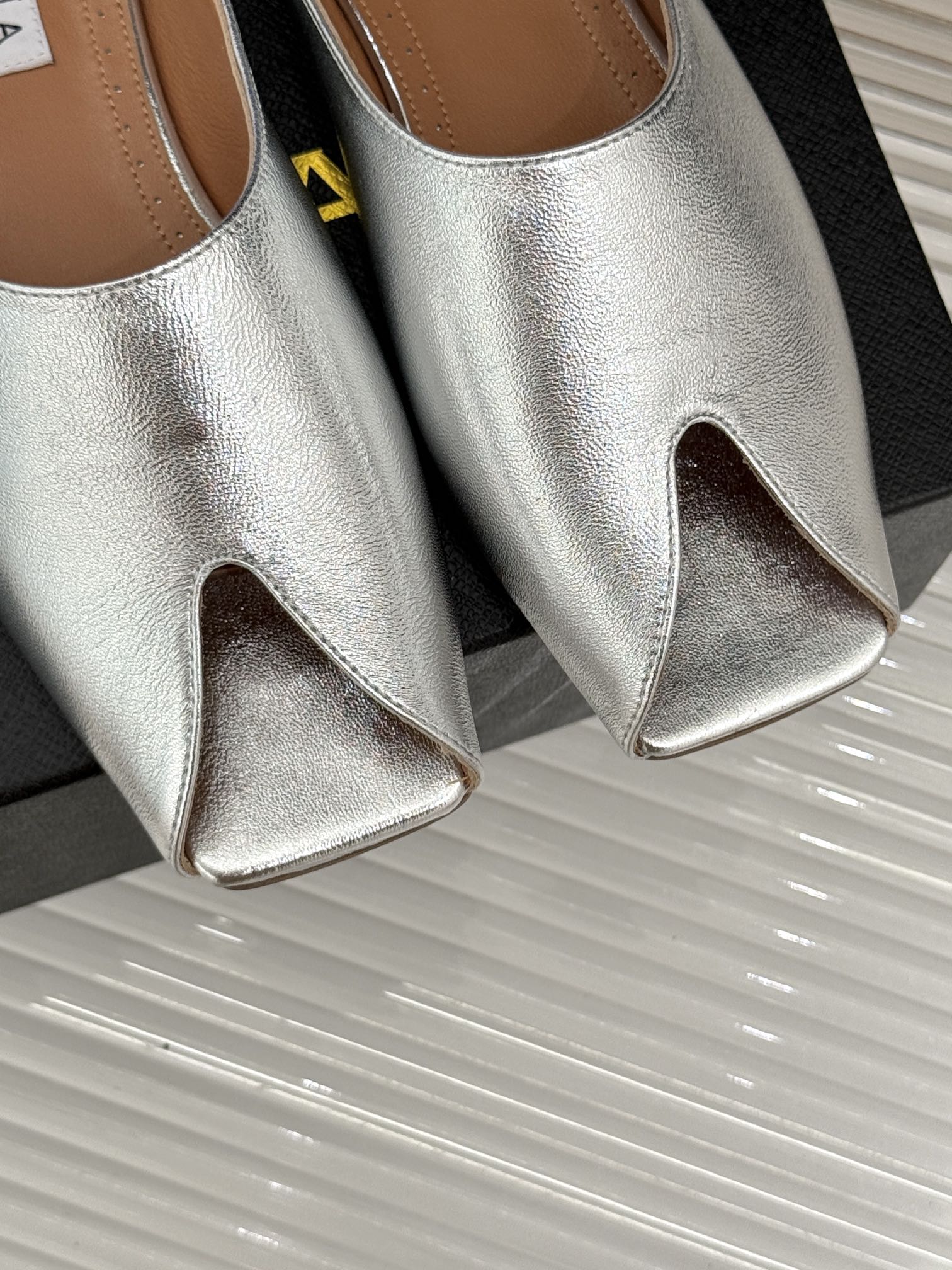 ALAIA FLAT MULE IN SILVER LAMBSKIN