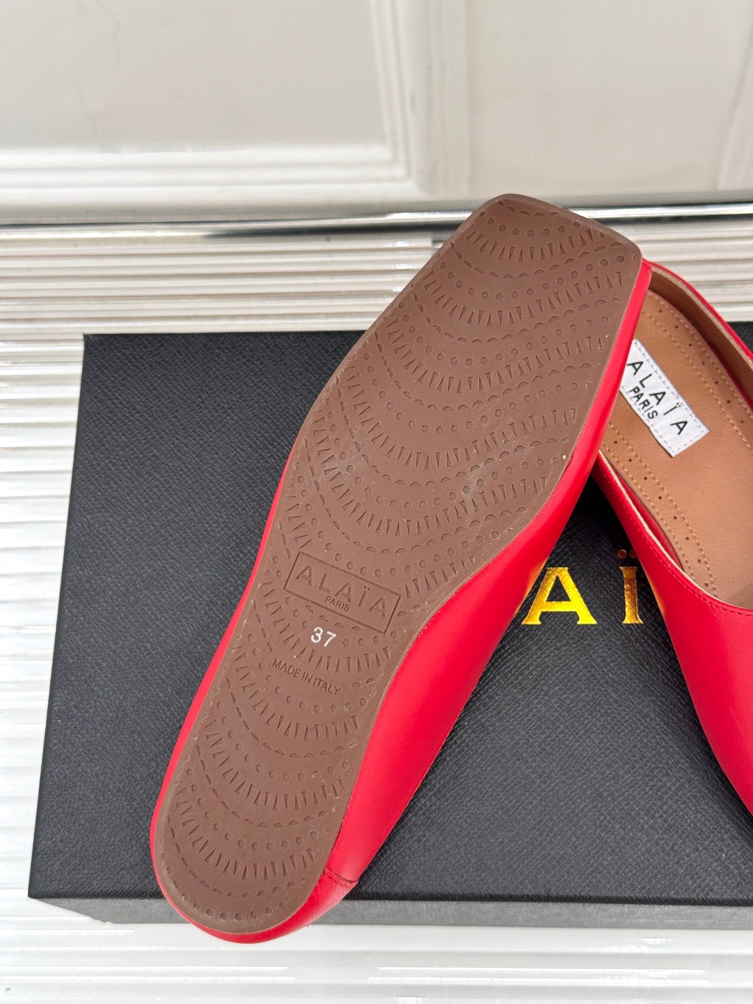ALAIA FLAT MULE IN CRIMSON RED LAMBSKIN