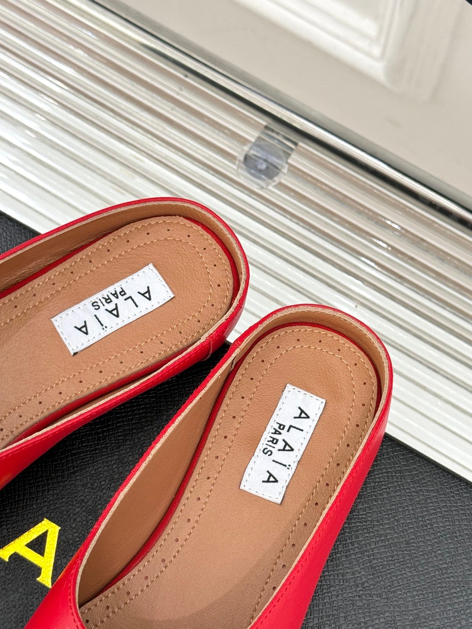 ALAIA FLAT MULE IN CRIMSON RED LAMBSKIN