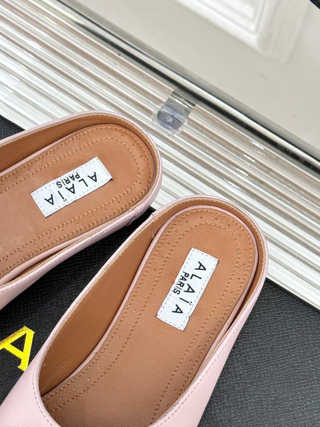 ALAIA FLAT MULE IN LIGHT PINK LAMBSKIN WITH GOLD HARDWARE