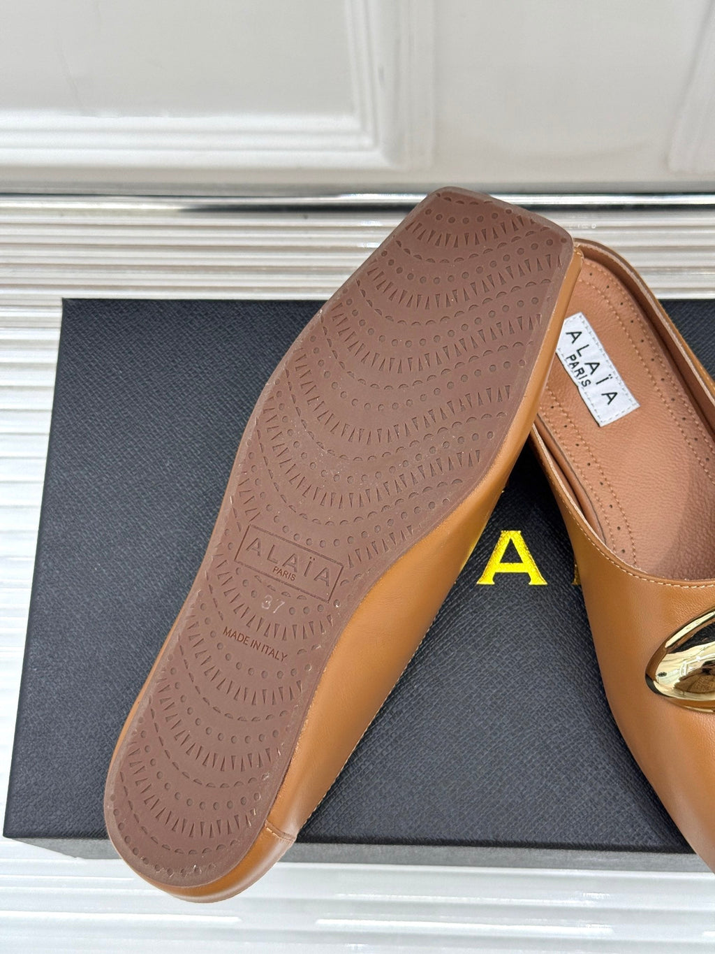 ALAIA FLAT MULE IN BRONZE BROWN LAMBSKIN WITH GOLD HARDWARE