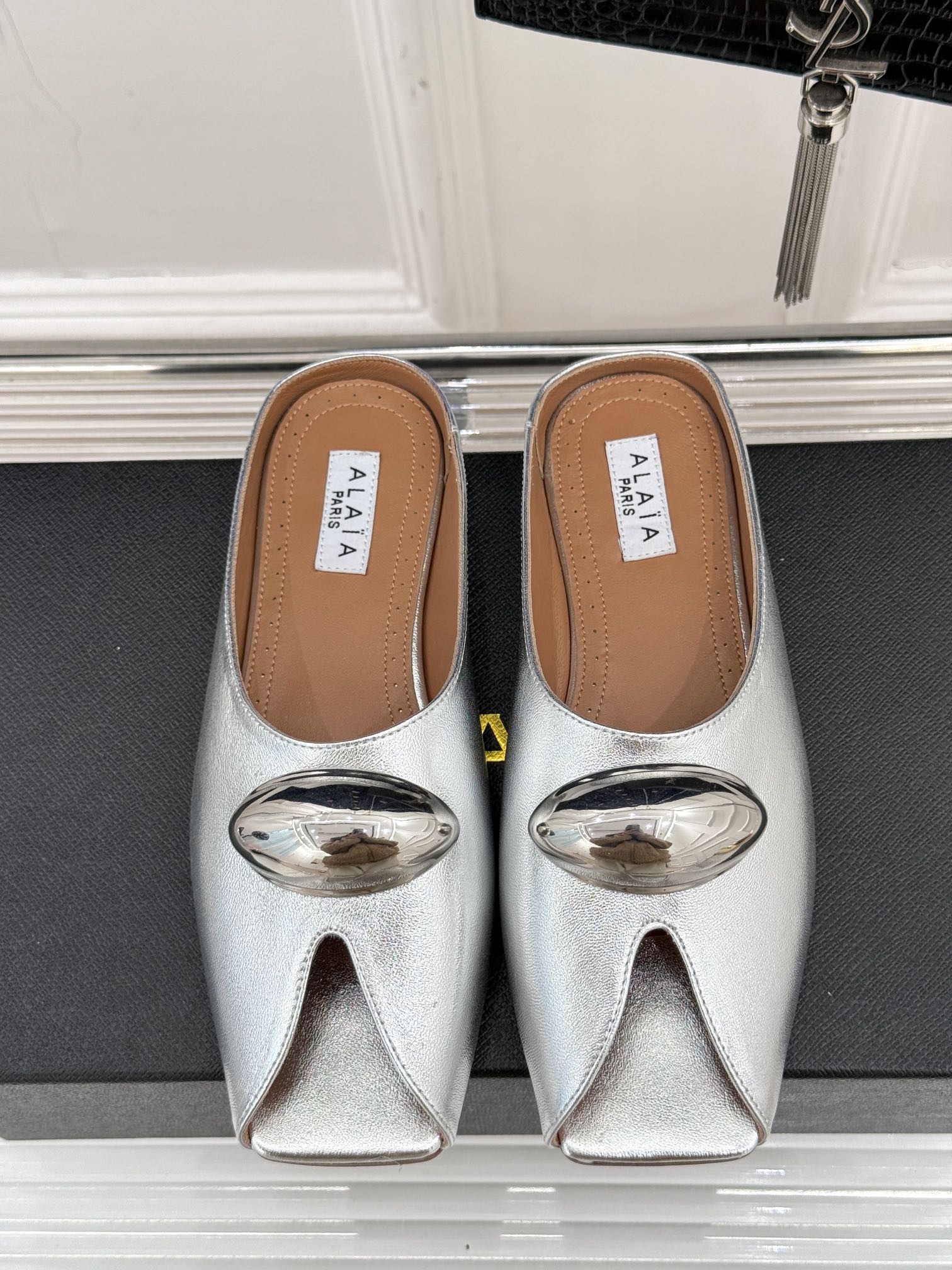 ALAIA FLAT MULE IN SILVER LAMBSKIN WITH SILVER HARDWARE