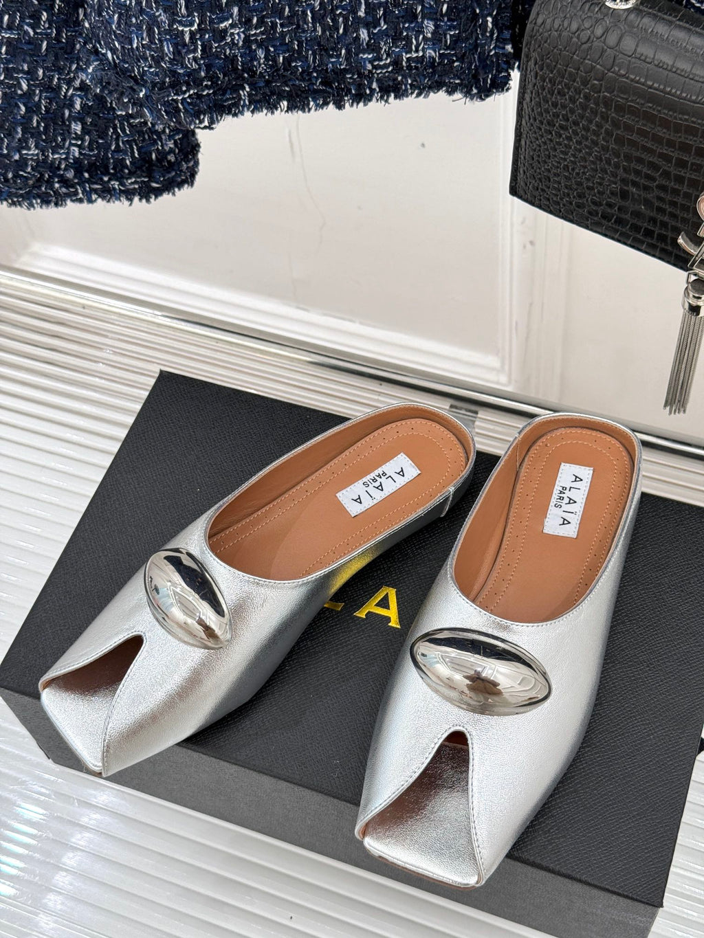 ALAIA FLAT MULE IN SILVER LAMBSKIN WITH SILVER HARDWARE