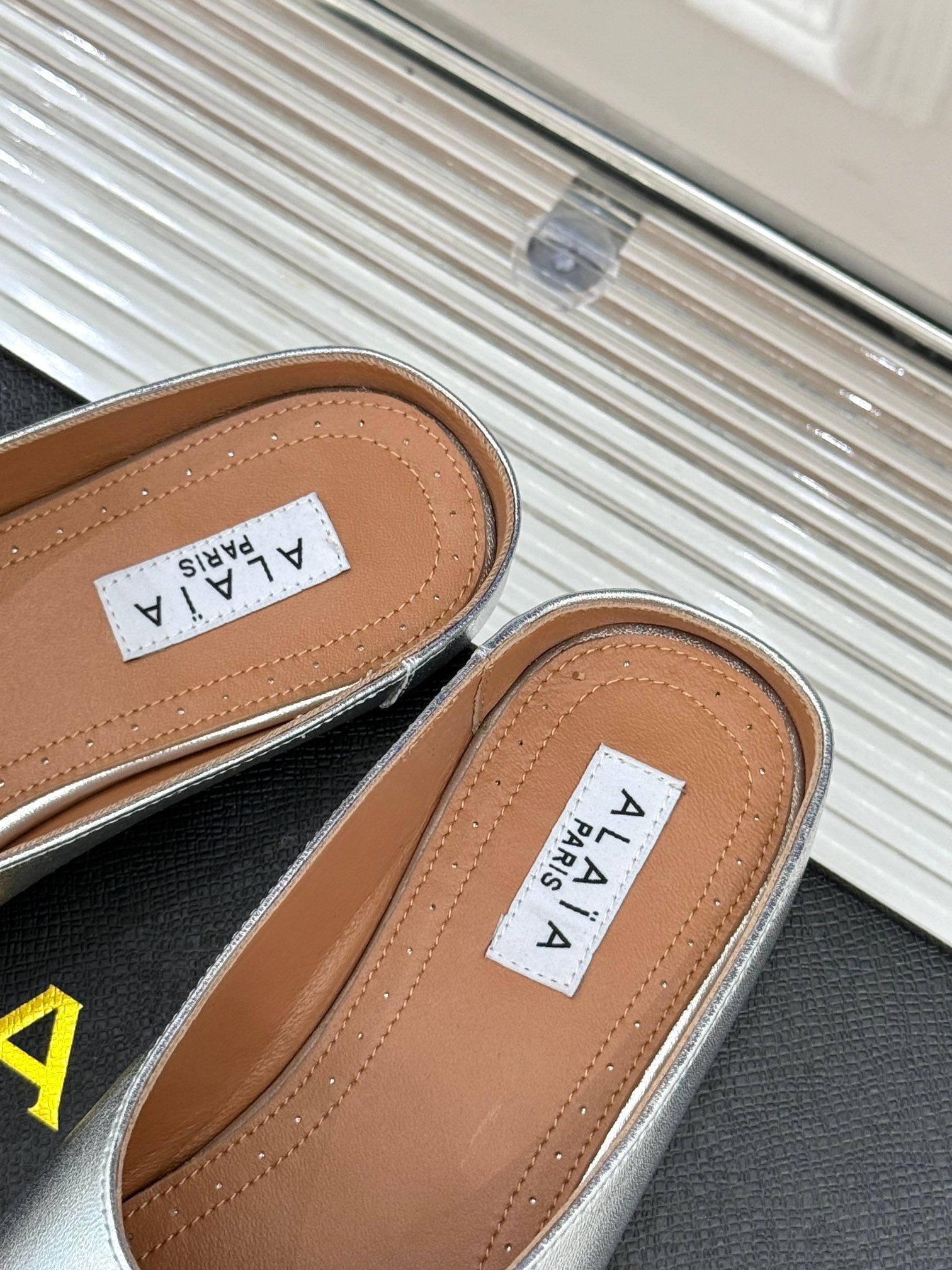 ALAIA FLAT MULE IN SILVER LAMBSKIN WITH SILVER HARDWARE