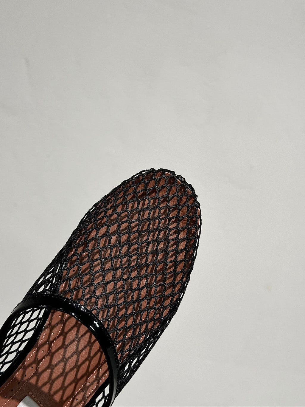 ALAIA FLAT MULES IN BLACK MESH FISHNET