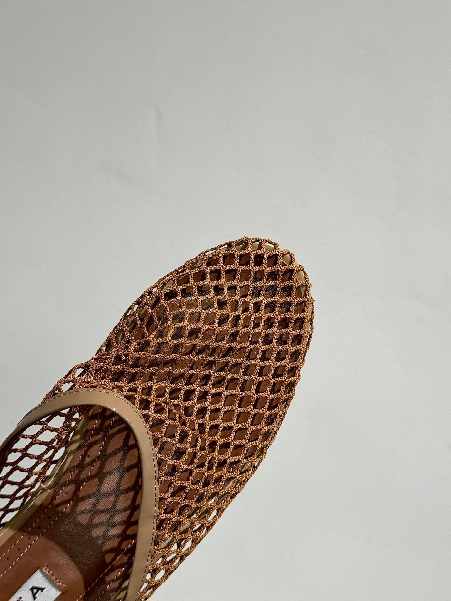 ALAIA FLAT MULES IN COPPER BROWN MESH FISHNET