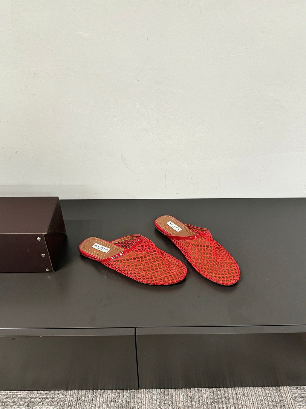 ALAIA FLAT MULES IN CHERRY RED MESH FISHNET
