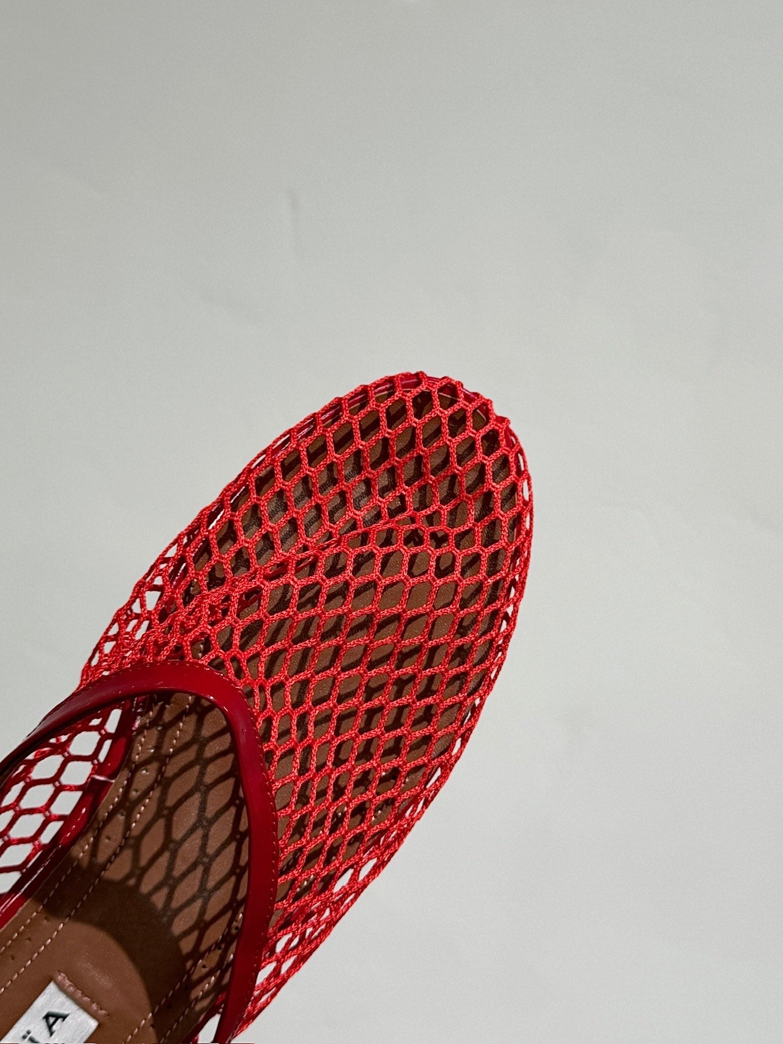ALAIA FLAT MULES IN CHERRY RED MESH FISHNET