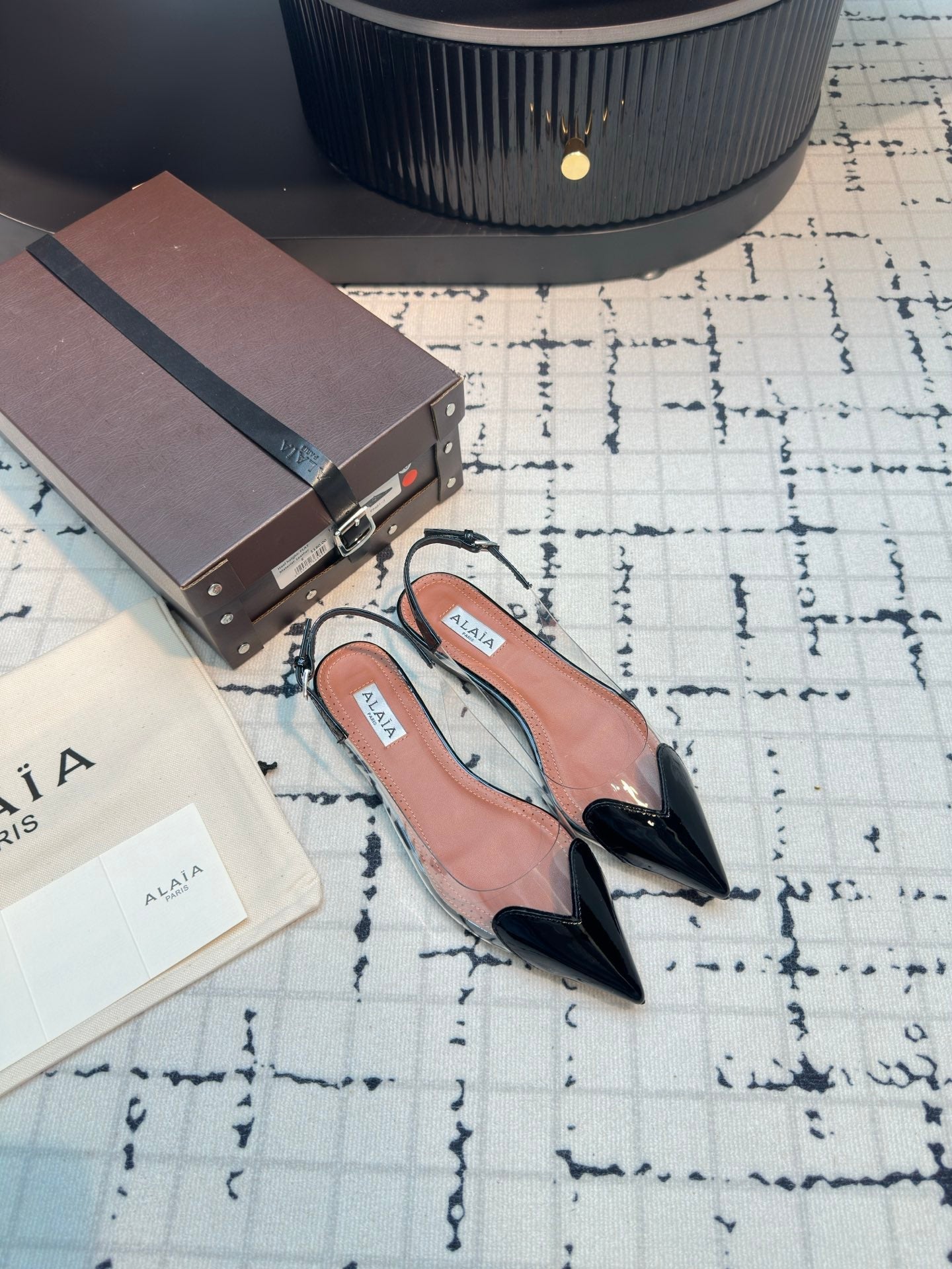 ALAIA FLAT SLINGBACK IN BLACK PATENT CALFSKIN AND FILM