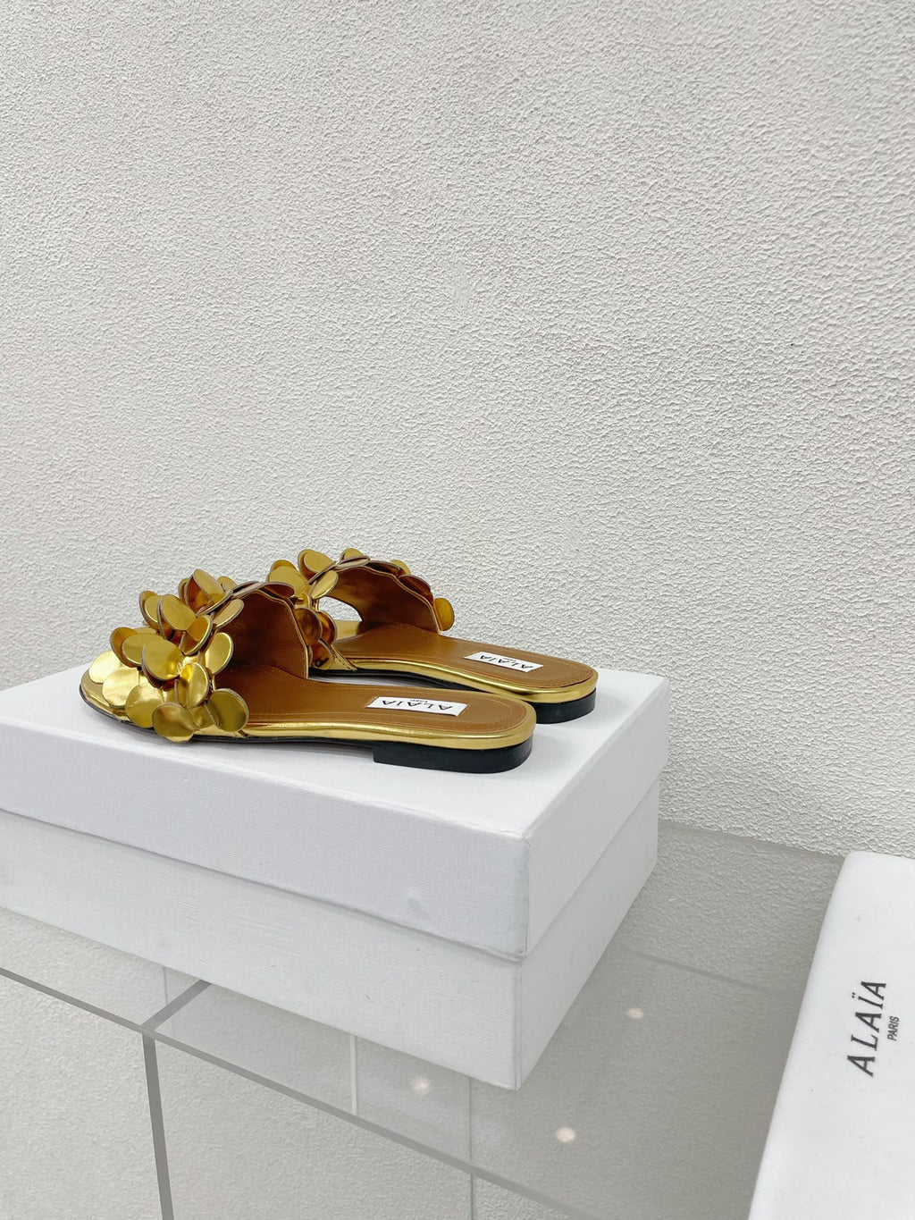 ALAIA FLAT MULE IN GOLDEN GLOSSY LAMBSKIN