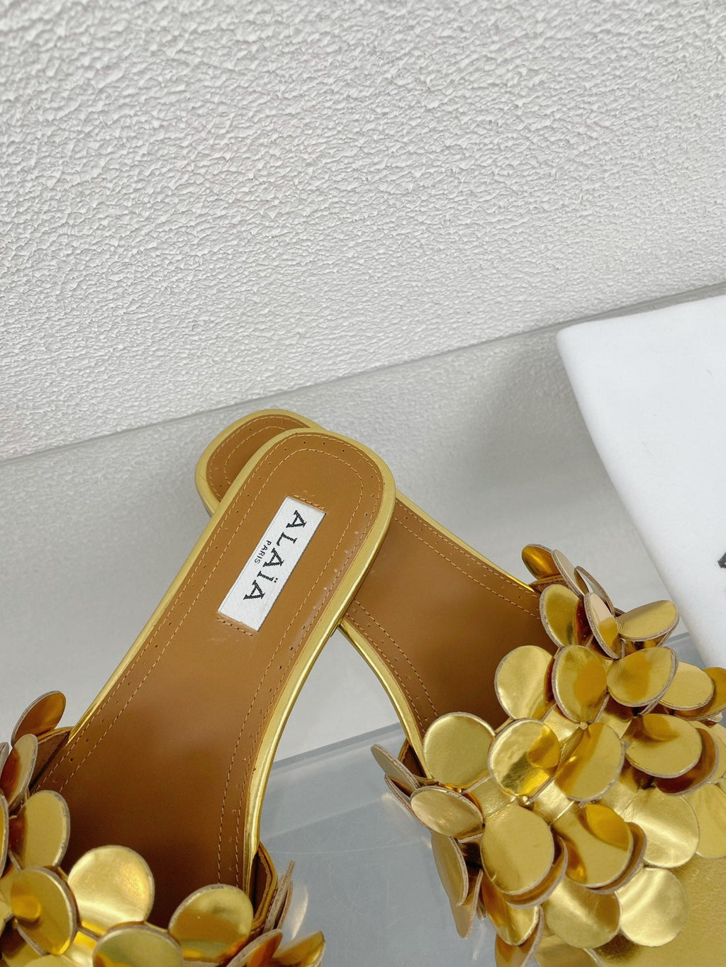 ALAIA FLAT MULE IN GOLDEN GLOSSY LAMBSKIN