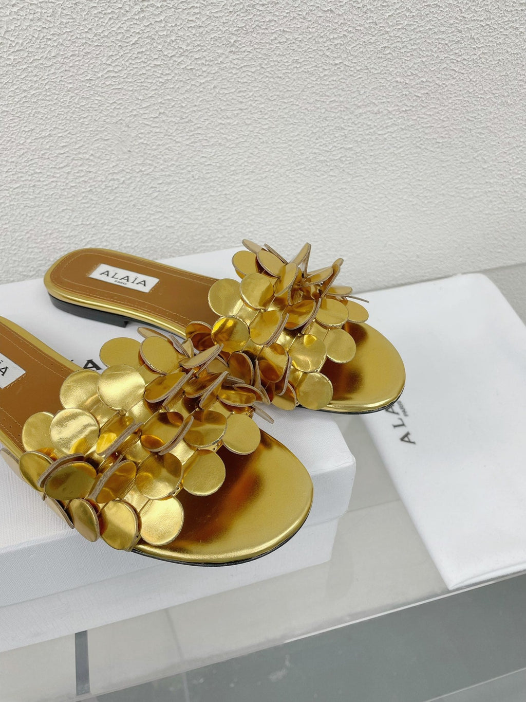 ALAIA FLAT MULE IN GOLDEN GLOSSY LAMBSKIN