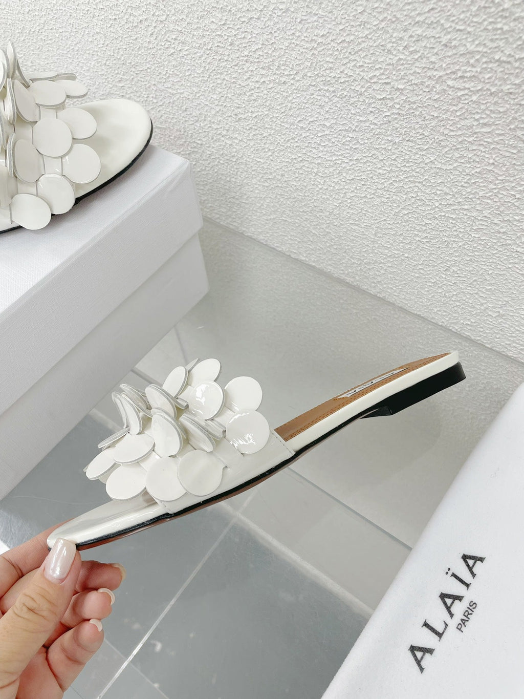 ALAIA FLAT MULE IN WHITE GLOSSY LAMBSKIN