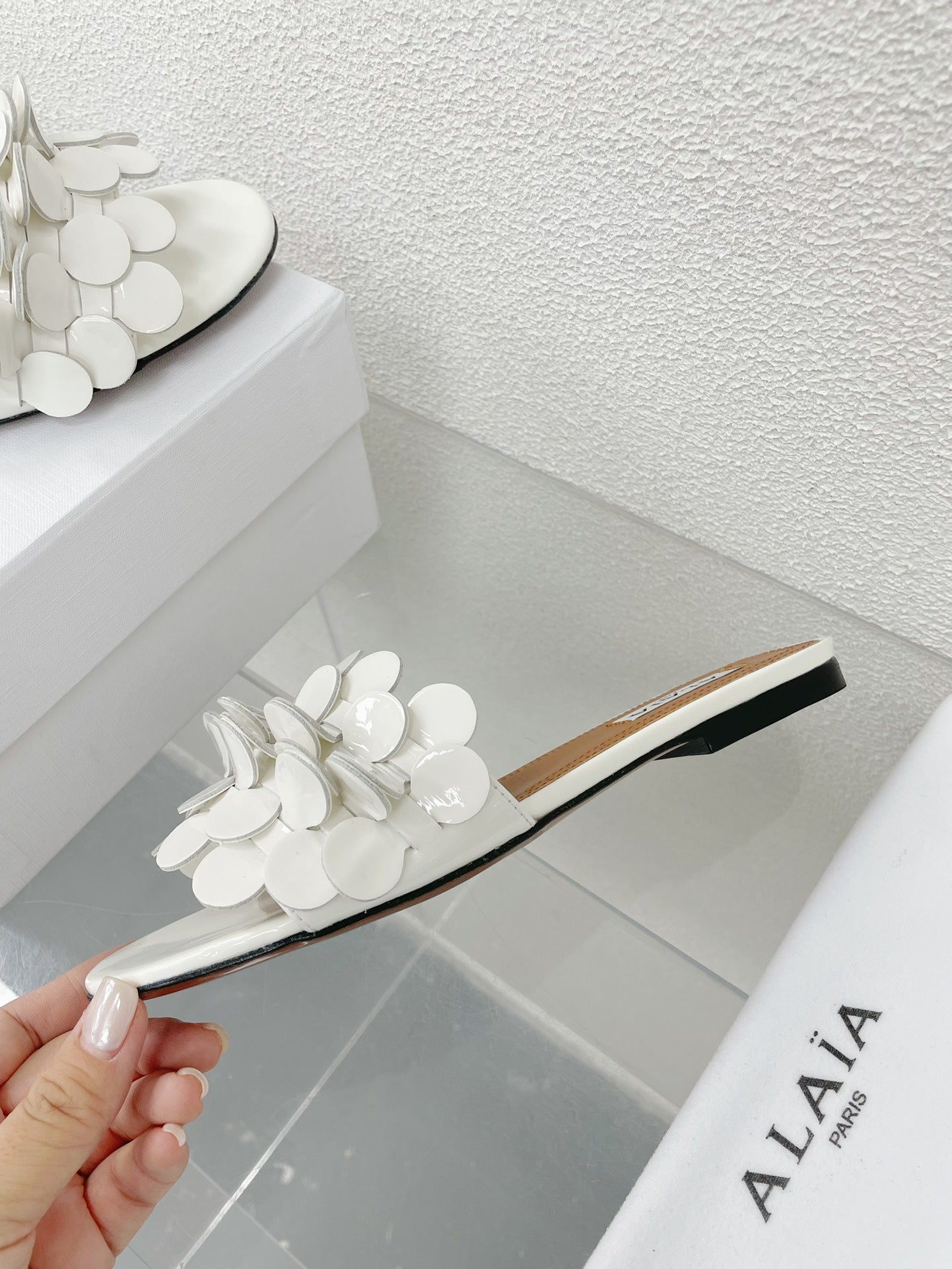 ALAIA FLAT MULE IN WHITE GLOSSY LAMBSKIN