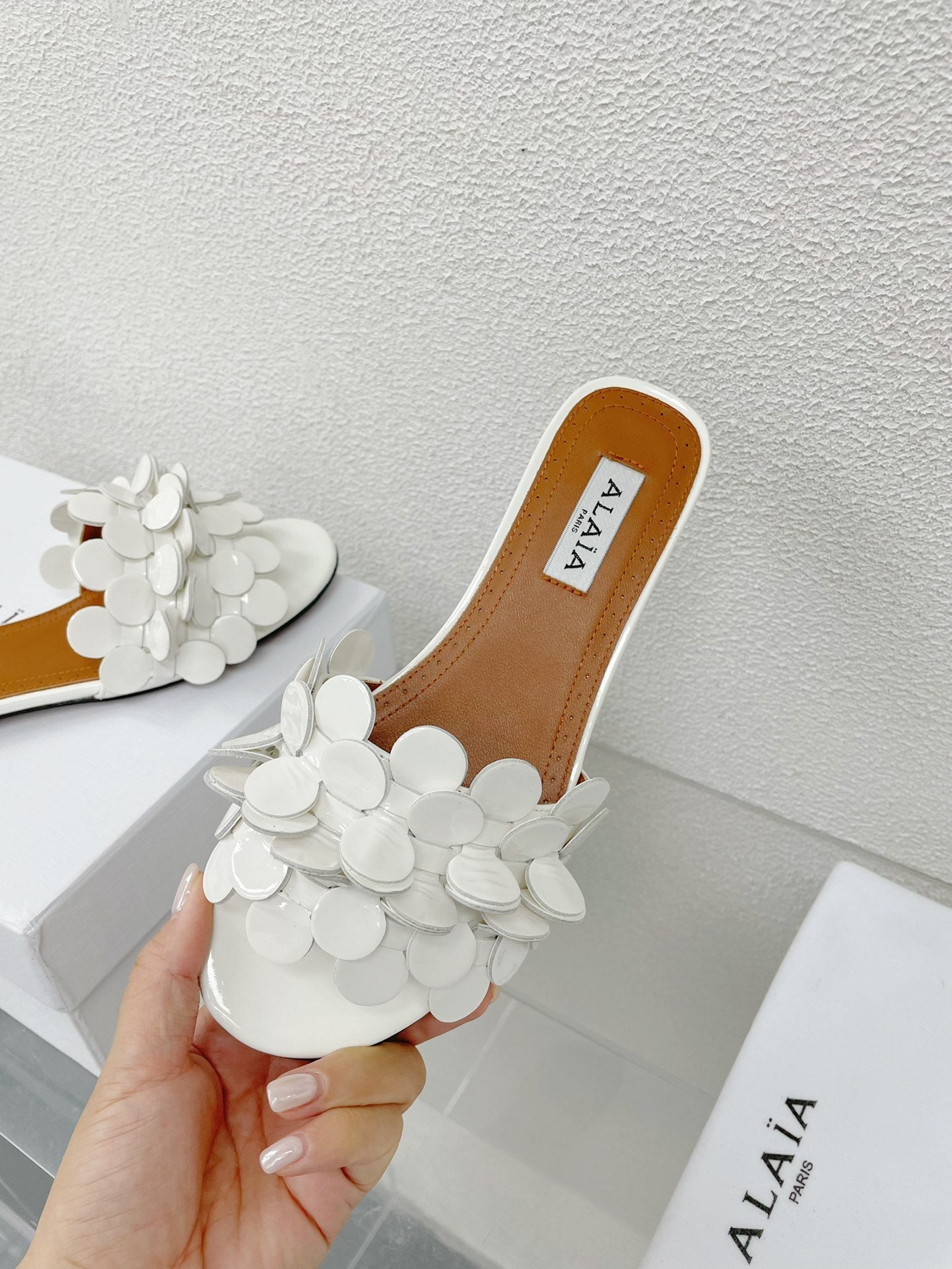 ALAIA FLAT MULE IN WHITE GLOSSY LAMBSKIN