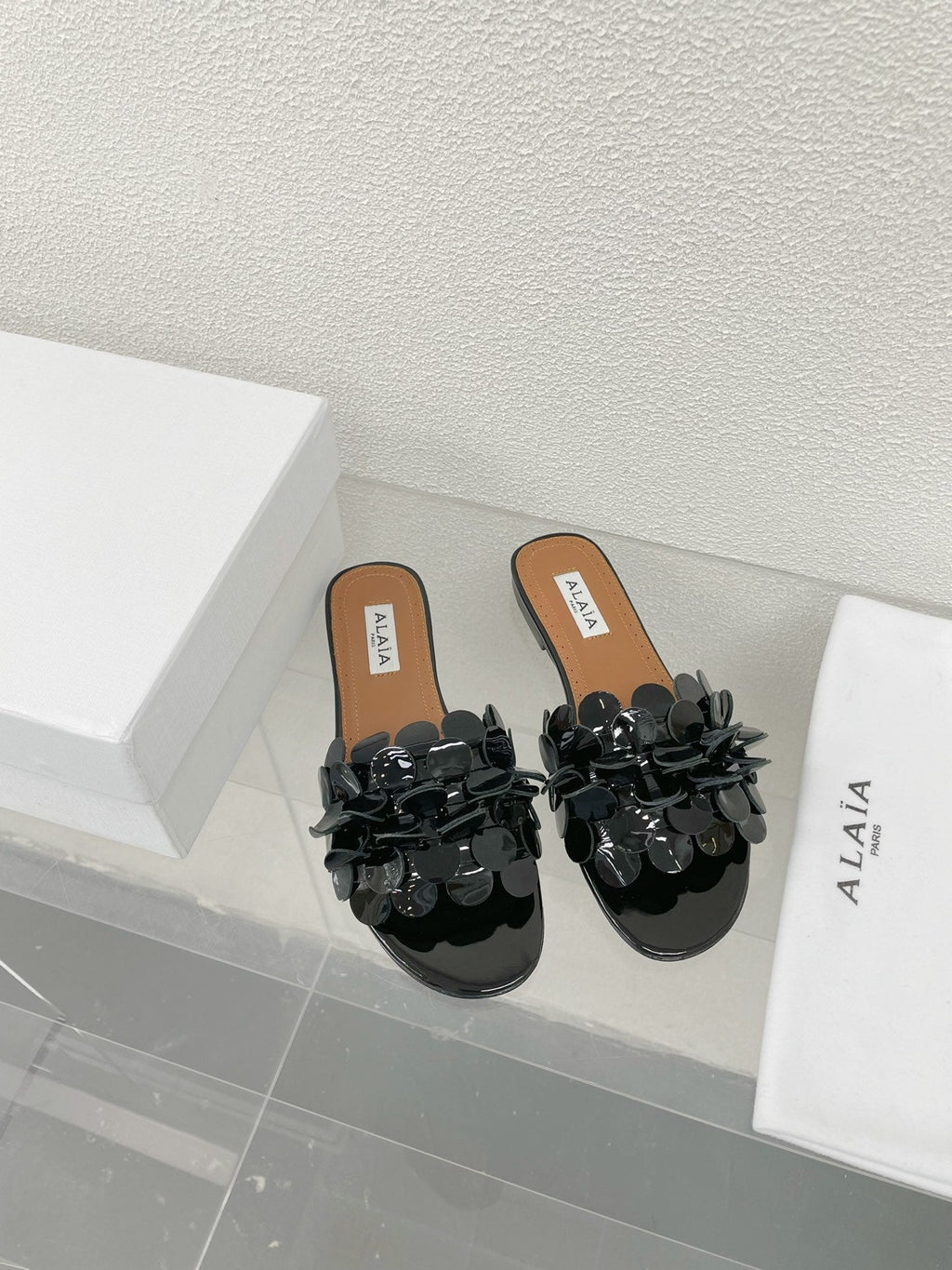 ALAIA FLAT MULE IN BLACK GLOSSY LAMBSKIN