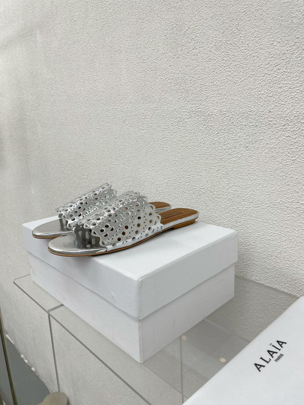 ALAIA VIENNE FLAT MULES IN SILVER LAMBSKIN