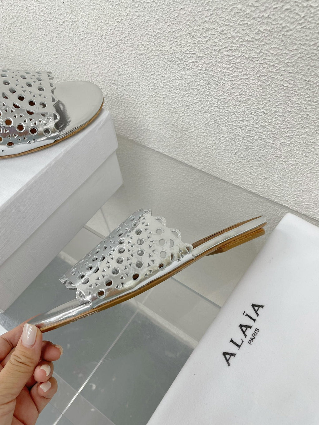 ALAIA VIENNE FLAT MULES IN SILVER LAMBSKIN
