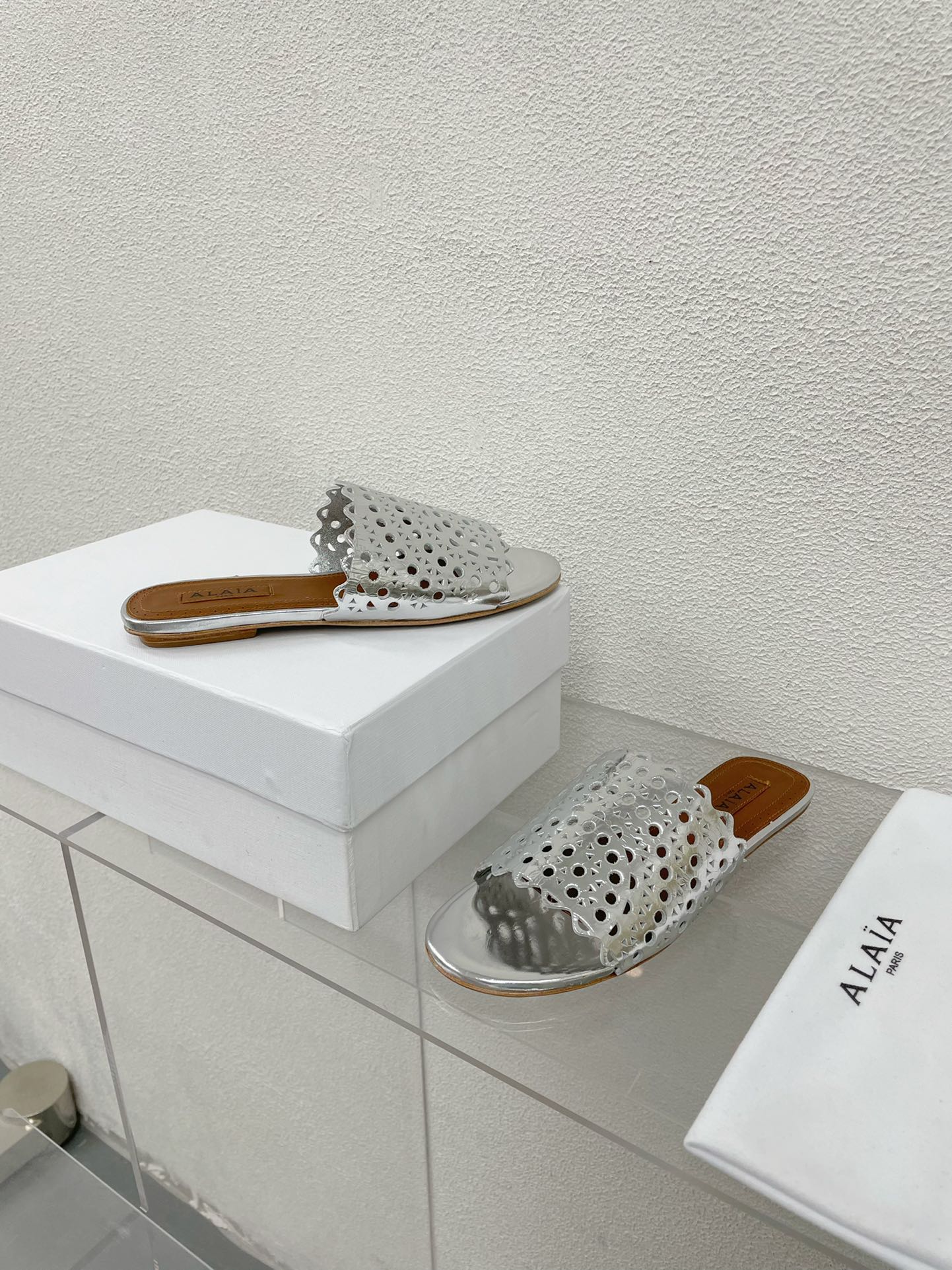 ALAIA VIENNE FLAT MULES IN SILVER LAMBSKIN