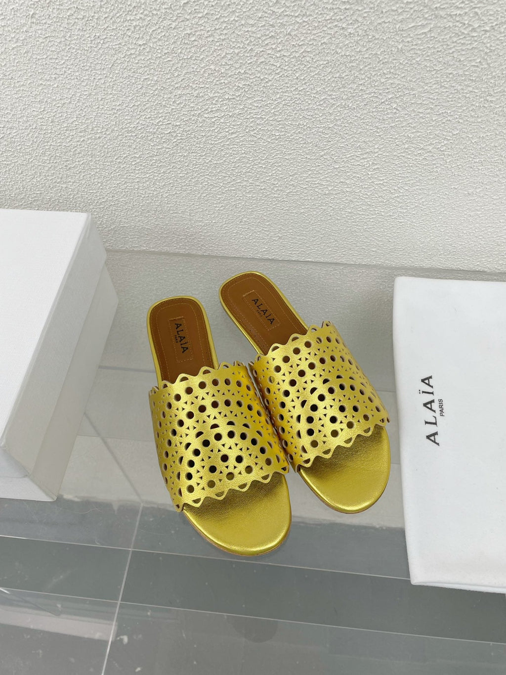 ALAIA VIENNE FLAT MULES IN GOLDEN LAMBSKIN
