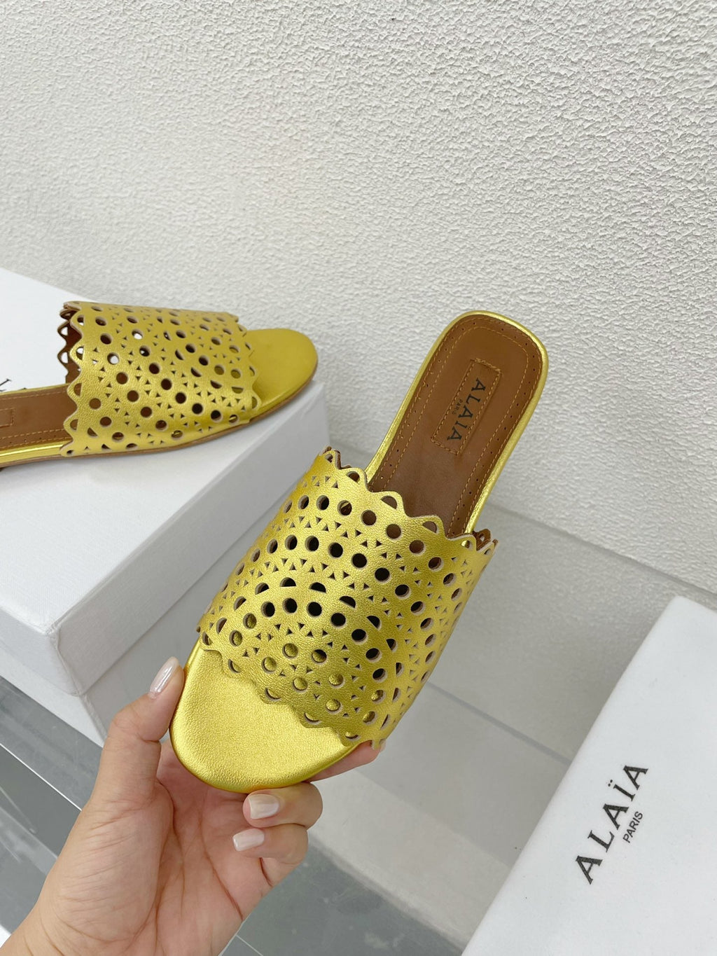 ALAIA VIENNE FLAT MULES IN GOLDEN LAMBSKIN