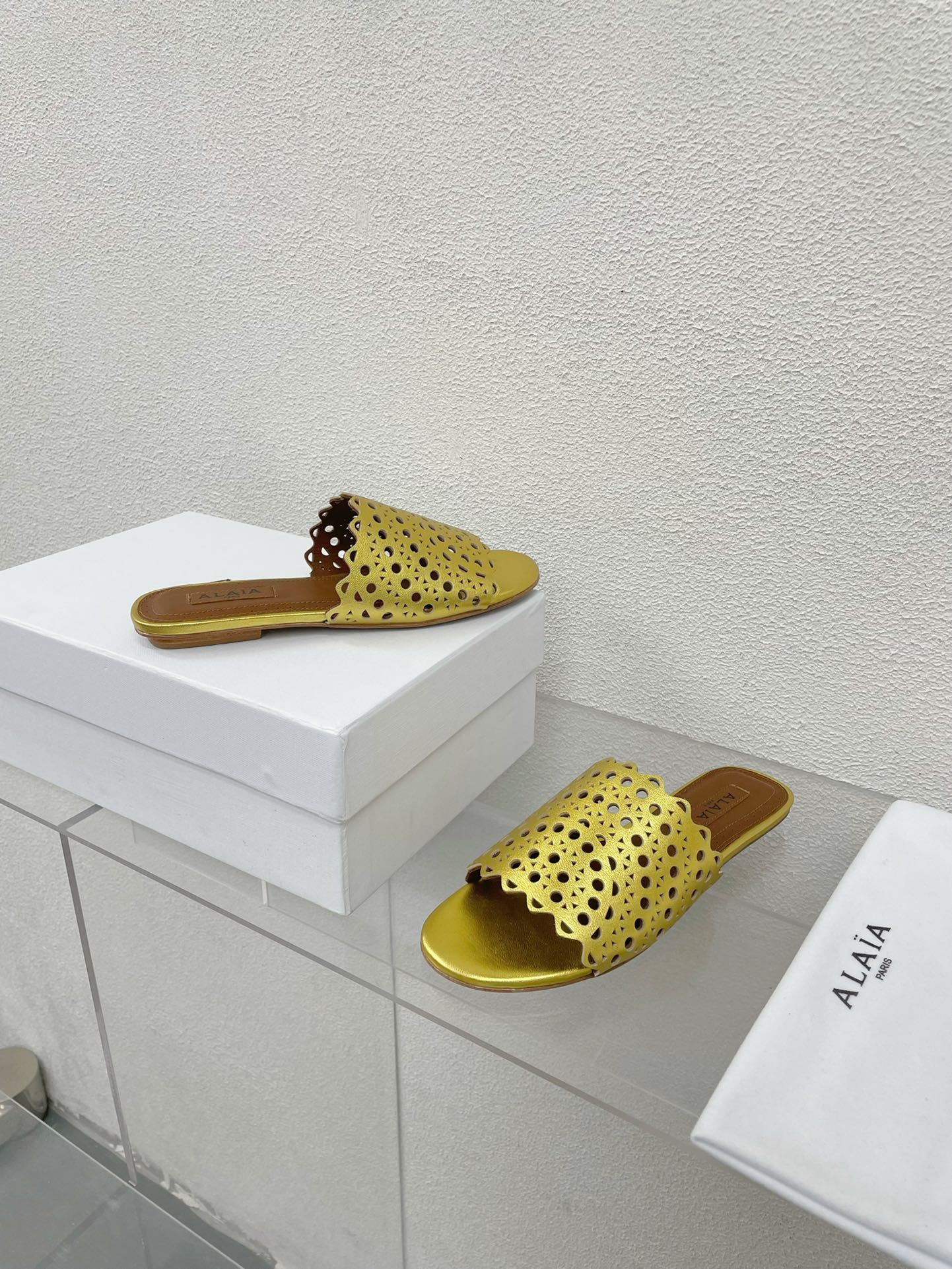 ALAIA VIENNE FLAT MULES IN GOLDEN LAMBSKIN