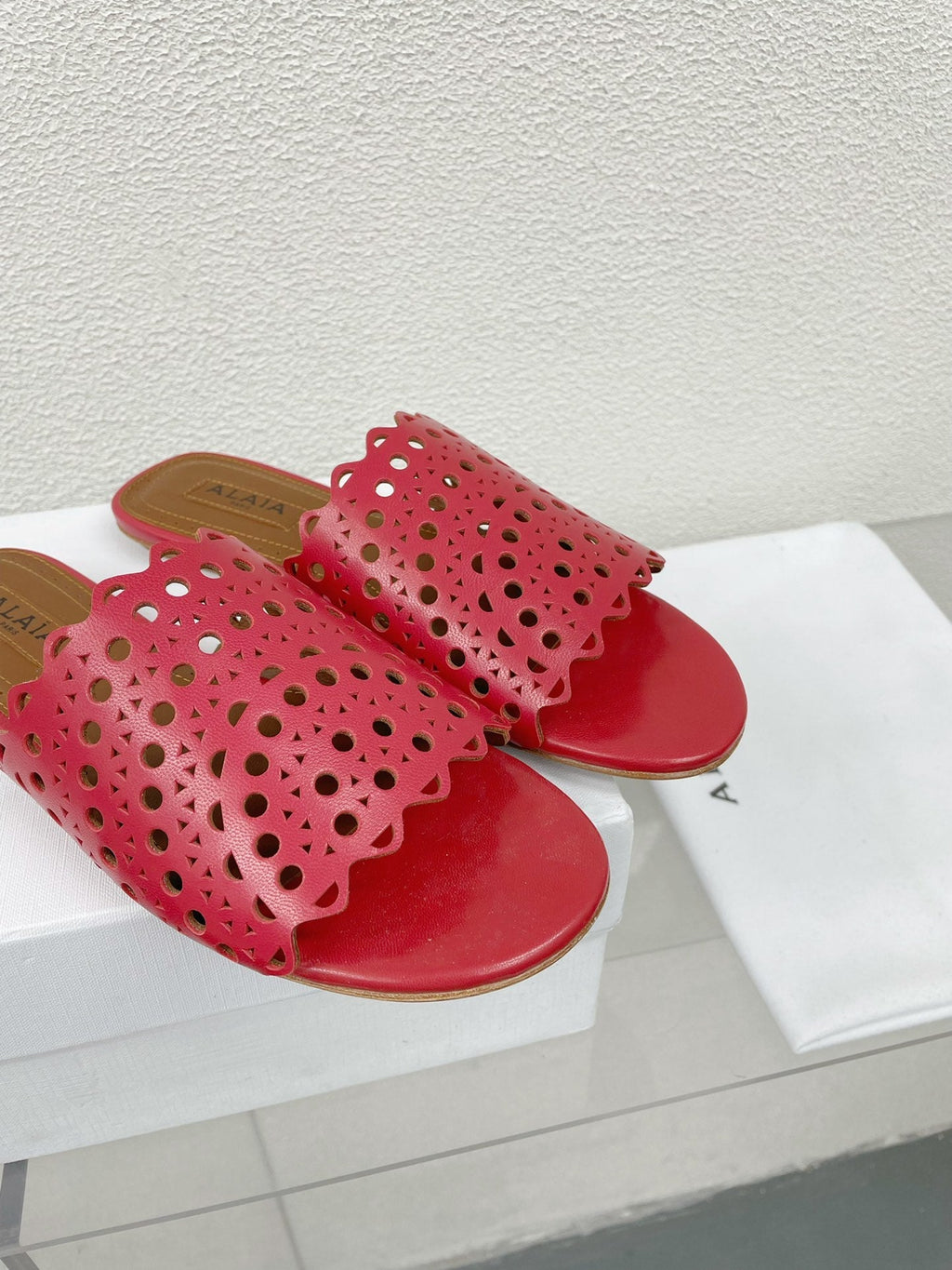 ALAIA VIENNE FLAT MULES IN CHERRY RED LAMBSKIN