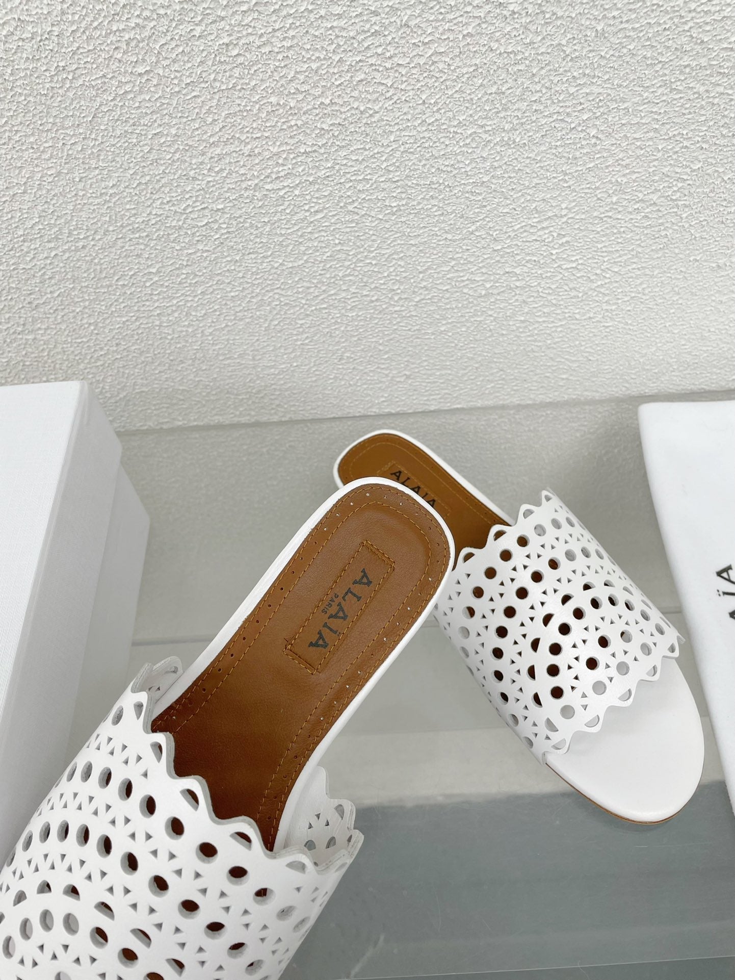 ALAIA VIENNE FLAT MULES IN WHITE LAMBSKIN