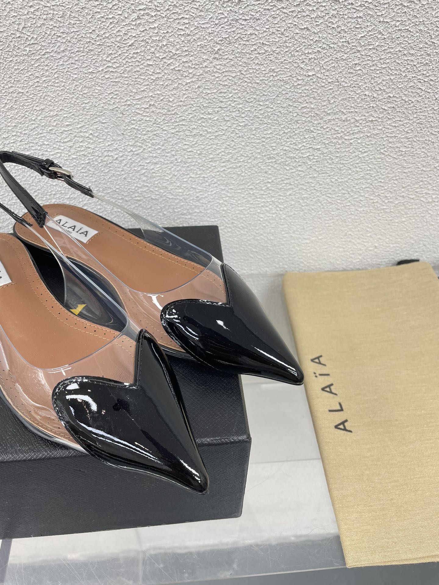 ALAIA LE COEUR FLAT SLINGBACKS IN BLACK PATENT LAMBSKIN