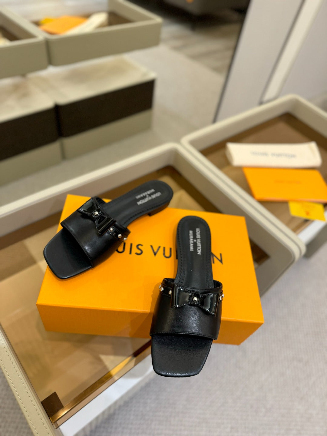 LV X TM 6AM FLAT MULE IN BLACK CALFSKIN