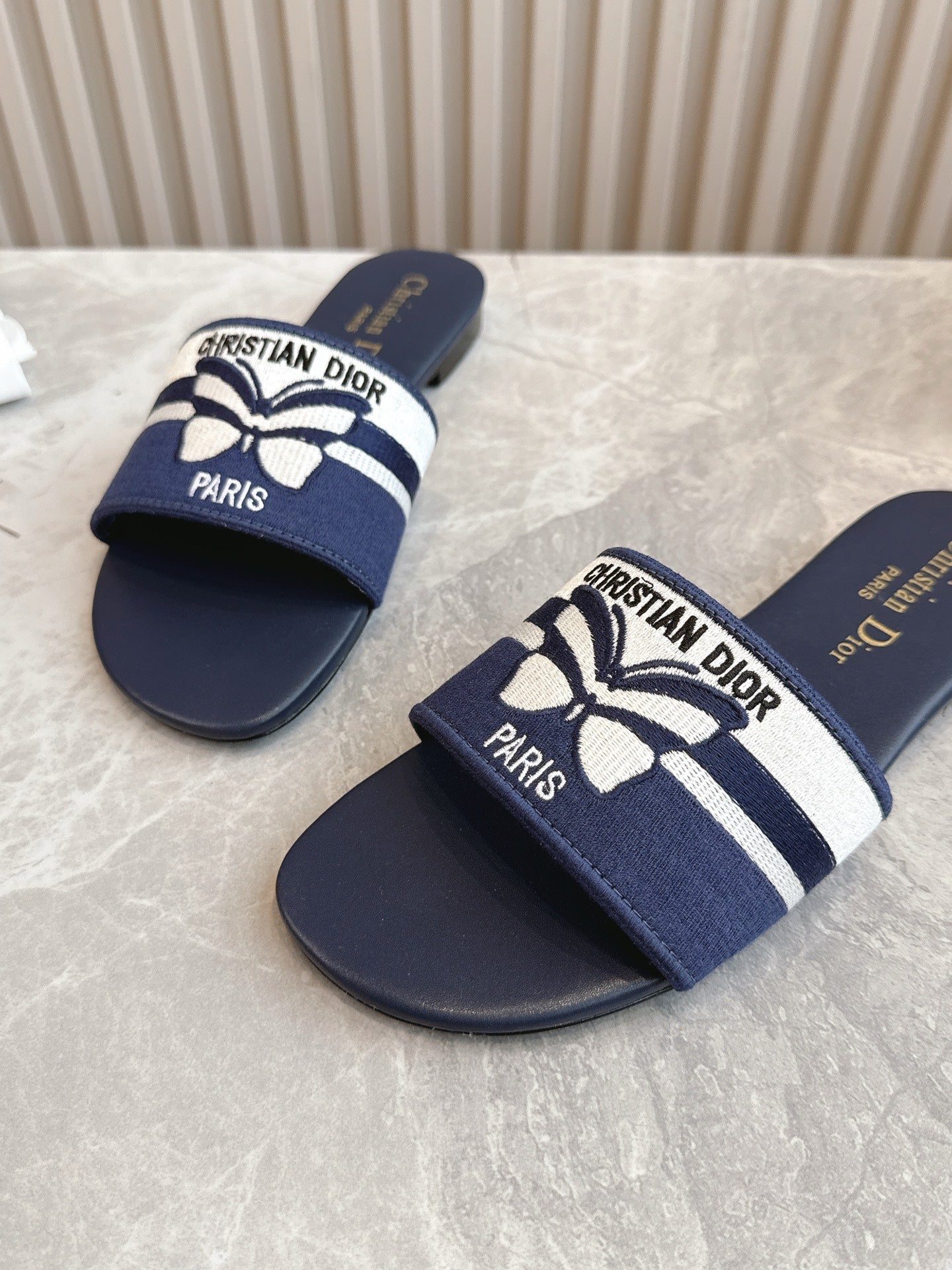 DIOR FLAT SLIDES 25S IN MIDNIGHT BLUE CALFSKIN AND FABRIC EMBROIDERED BUTTERFLY MOTIF