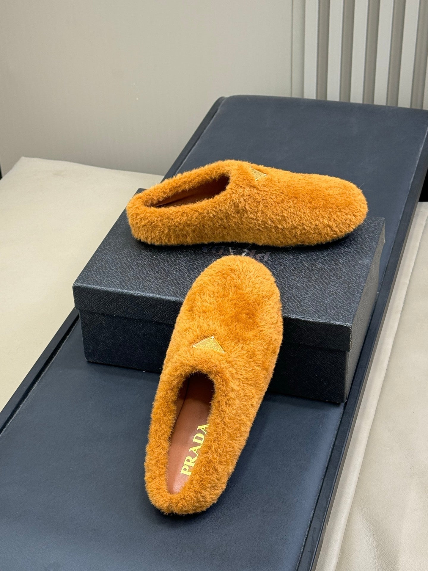 PRADA 25S CLOGS IN DARK ORANGE SHEARLING