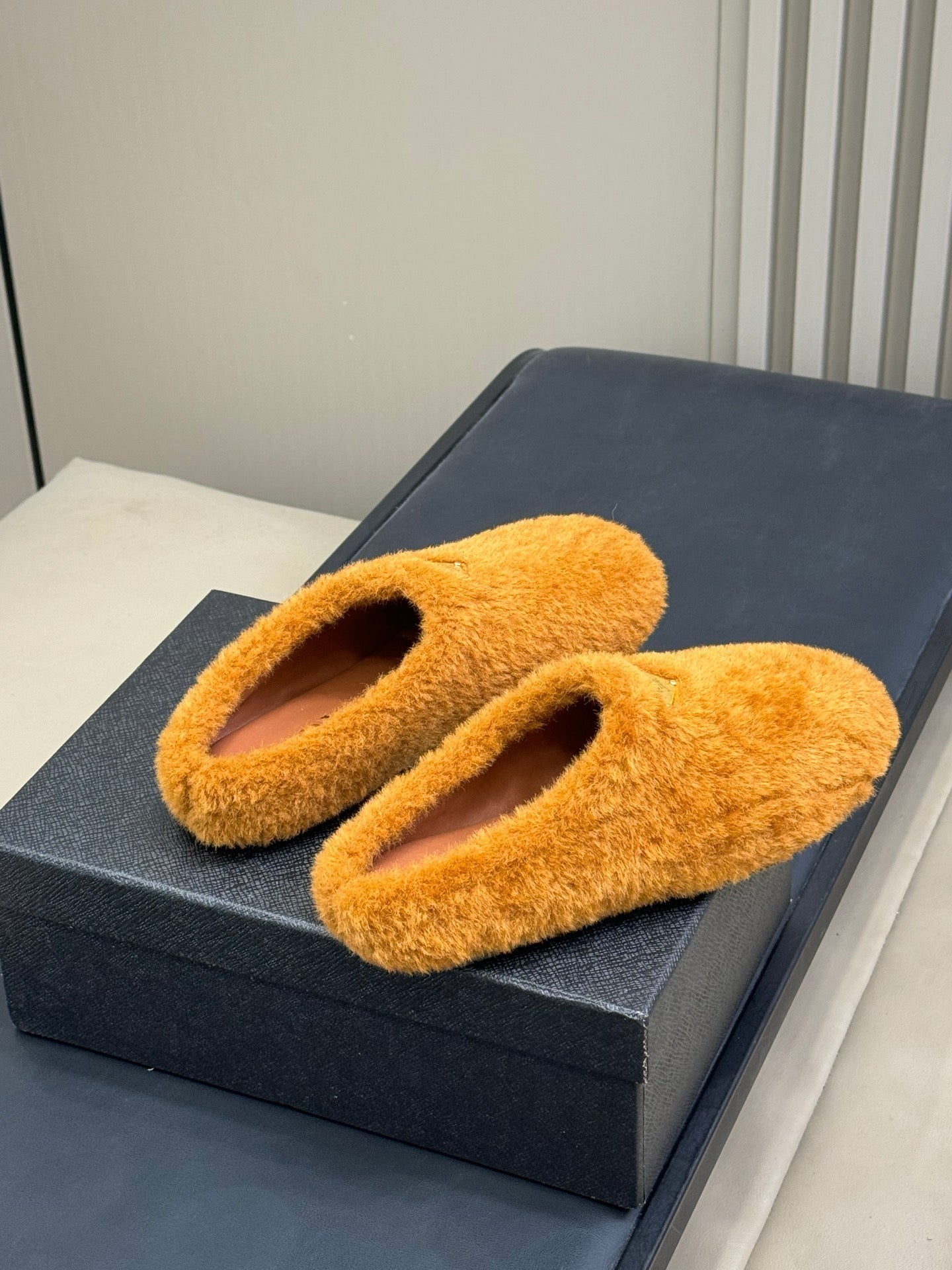 PRADA 25S CLOGS IN DARK ORANGE SHEARLING