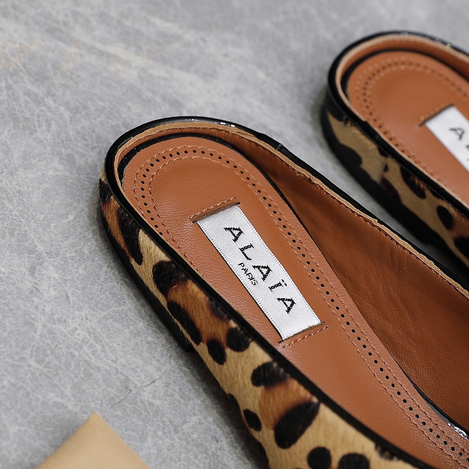 ALAIA FLAT MULE IN LEOPARD LAMBSKIN