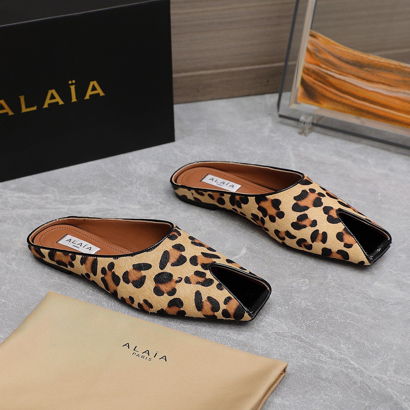 ALAIA FLAT MULE IN LEOPARD LAMBSKIN