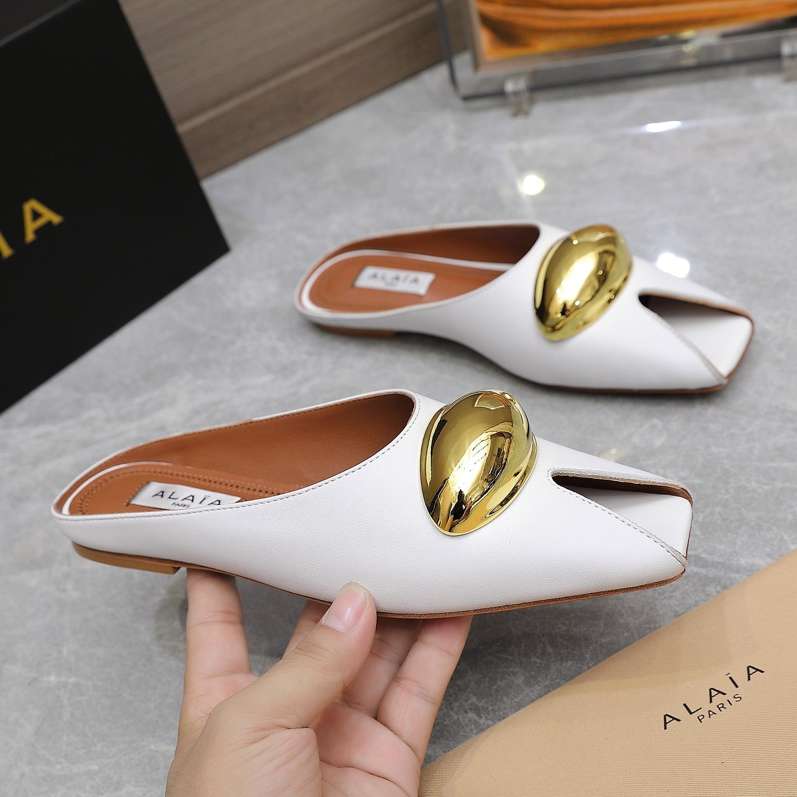 ALAIA FLAT MULE IN WHITE LAMBSKIN WITH GOLD HARDWARE