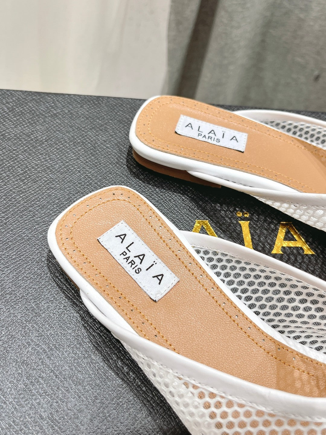 ALAIA FLAT MULES IN WHITE MESH FISHNET