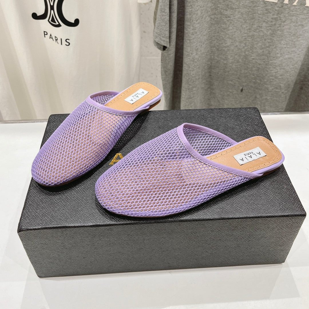 ALAIA FLAT MULES IN LIGHT PURPLE MESH FISHNET
